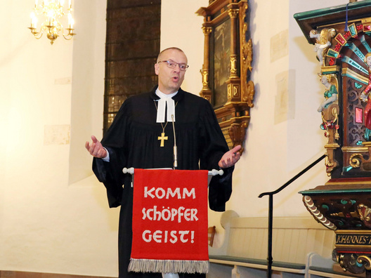 Bischof Thomas Adomeit am Stehpult in der Kirche.