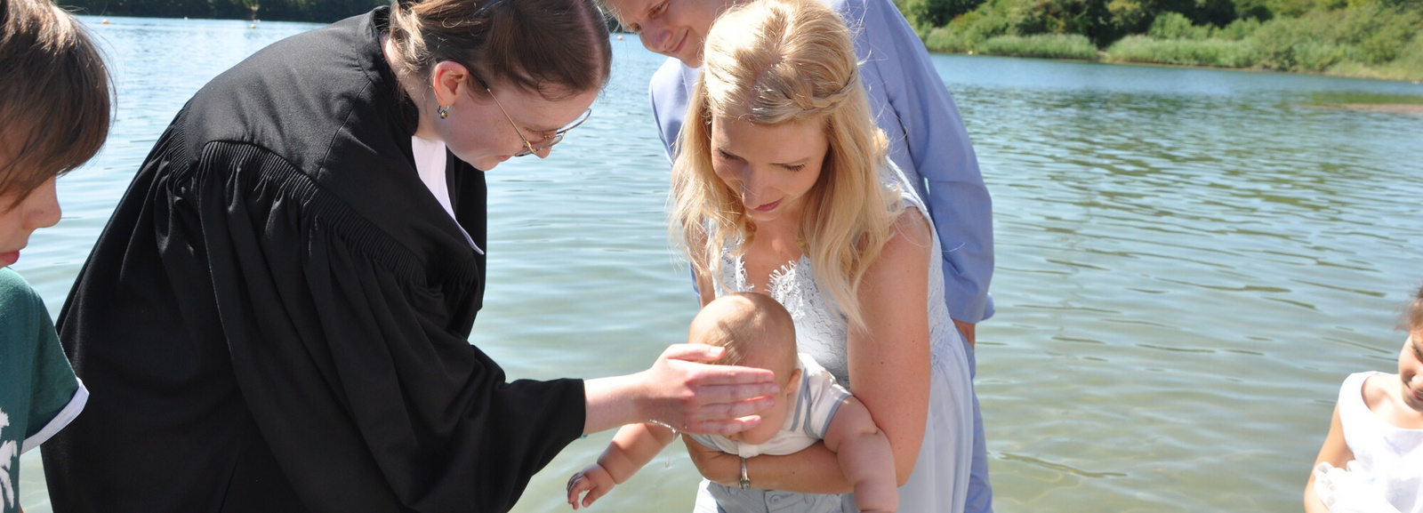 Ein Kind wird von Pfarrerin Katharina Ruhwedel beim Bensheim Tauffest 2022 im Badesee getauft.